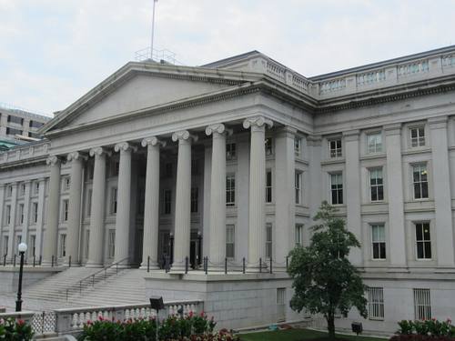 Fachada principal del edificio del Departamento del Tesoro de EE. UU. en Washington D.C., con columnas jónicas y el rótulo "THE TREASURY DEPARTMENT" tallado en el friso