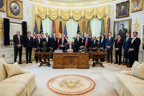 Donald Trump sentado al Resolute Desk del Despacho Oval, rodeado de miembros del Gabinete y asesores, momentos antes de firmar la orden ejecutiva sobre computación cuántica el 22 de junio de 2026
