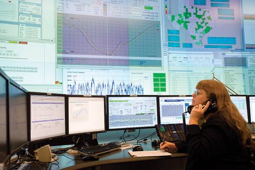 Una despachadora de ERCOT, el operador de la red eléctrica de Texas, supervisa en su sala de control varias pantallas con las curvas de generación y demanda en tiempo real y el mapa de zonas de carga del estado.
