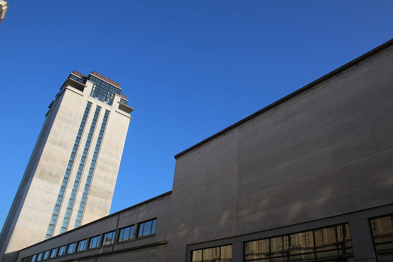 La Boekentoren, torre de la Biblioteca de la Universidad de Gante, vista desde la calle contra un cielo despejado